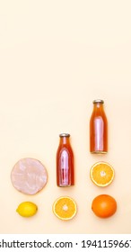Vertical banner with two bottles of kombucha tea, scoby and citrus fruits for additional flavors on yellow pastel background with copy space. Orange, lemon. Healthy fermented drink. Flatlay mockup