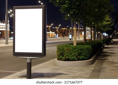 Vertical Billboard Advertising In The Night City. Bright Lights, Smooth Shrubs. Mock-up.