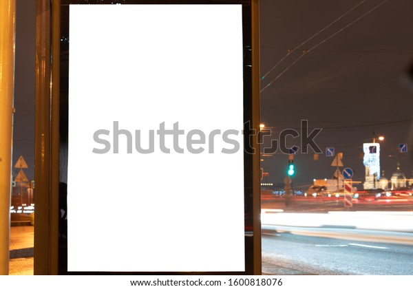 Vertical billboard glow box\
near the road, line of cars. Long exposure. white field for\
advertising