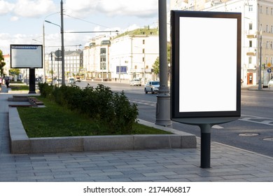 Vertical Billboard Near The Road In The City. The Bright Sun Burns The City. Mock-up.