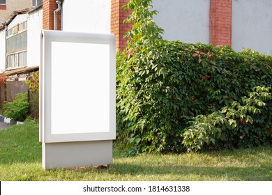 Vertical Billboard On A Green Lawn Near A Brick Wall, Mock Up.