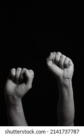 Vertical Black And White Image Of Two Arms With Clenched Fists Coming Out From Below. Close Shot Of A Woman's And A Man's Arm With Their Fingers Closed Together Leaving Copy Space.