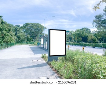 Vertical Blank Advertising Poster Banner Mockup At Empty Bus Stop Shelter By Main Road, Greenery Behind; Out-of-home OOH Vertical Billboard Media Display Space