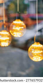 Vertical blurred background featuring three glowing Edison-style light bulbs.