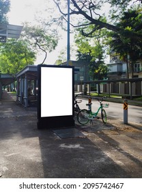 Vertical Bus Stop Billboard Ad Mock Up In A Residential Area Surrounded By Greenery