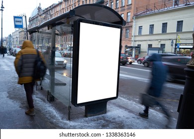 Vertical City Billboard In A Public Transport Stop Bus Shelter. MOCKUP. In The City Center In The Afternoon With Snow In The Winter Outdoor Advertising Ad With Blurred People Passing By