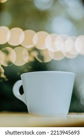 Vertical Close Up Coffee Cup On Outdoor Terrace Table With Bokeh Christmas Lights