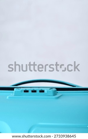 Vertical close up of numeric combination lock on blue luggage