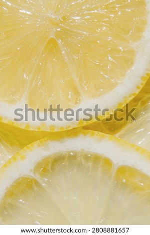 Vertical close up of overlapping fresh lemon slices forming a vibrant citrus background. Bright natural texture suitable for vitamin C, healthy nutrition, skincare, cosmetic ingredients