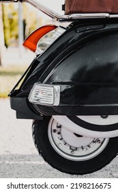 Vertical Close Up Picture Of Retro Black Motorbike's Wheel. This Back Part Of The Vehicle Contain The Rear Tyre And The Spare Tyre. Brake Light And Bike Basket