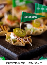 A Vertical Close Up View Of Nacho Layered Dip Appetizers Topped With Jalapenos Ready For Super Bowl Game Day.