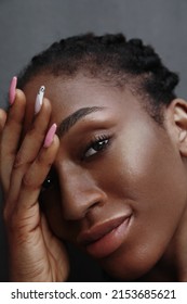 Vertical Close-up Of African American Young Woman With Glowing Skin Looking At The Camera. 