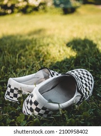 A Vertical Closeup Of The Checkerboard Shoes On The Grass 