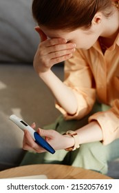 Vertical Closeup Of Crying Young Woman Holding Pregnancy Test At Home And Covering Eyes