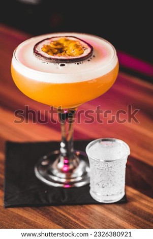 A vertical closeup of a pornstar martini cocktail with a passion fruit