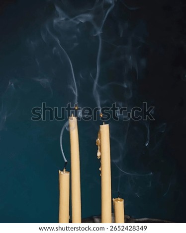 a vertical close-up shot featuring four cream-colored candles