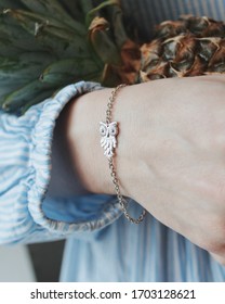 A Vertical Closeup Shot Of A Female Wearing A Bracelet With An Owl Pendant Charm