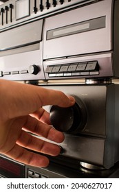 A Vertical Closeup Shot Of A Hand Adjusting The Sound On An Old Cd Player