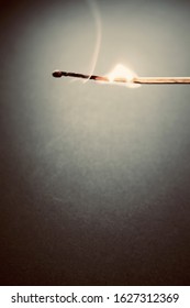 A Vertical Closeup Shot Of A Matchstick Burning Beautifully In A Dark Room