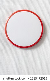 Vertical Close-up Shot Of A Round Blank Campaign Button On A White Shirt.    Copy Space.