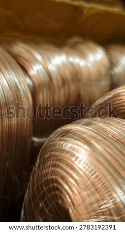 Vertical close-up of transparent speaker wire rolls wrapped in plastic packaging.