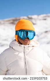 A Vertical Closeup Of The Young African American Woman In Snow Goggles And A White Down Jacket 