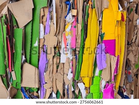 Vertical colored stack of waste  from pressed cardboard boxes, sorted and packed for recycling. Raw materials for the pulp industry. Garbage sorting secondary use of resources. Paper recycling photo