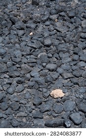 Vertical composition of dark volcanic rock fragments covering the terrain in Gran Canaria.
