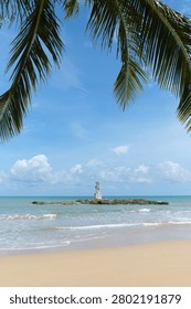 Vertical composition featuring a coastal lighthouse framed by tropical vegetation and open sea. Excellent visual for travel advertising, tourism brochures, destination marketing and hospitality campaigns.