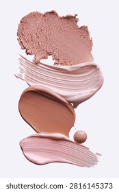 A vertical composition of makeup textures featuring creamy swipes of liquid foundation, soft pink concealer strokes, and a crumbly beige powder smudge on a clean background, perfect for beauty ads