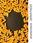 Vertical composition of peanut puff snacks forming circle with copy space, perfect for design background, banner, or packaging mockup