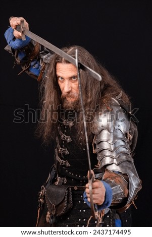 Vertical composition. Portrait of a medieval knight with a characteristic historical appearance with with two swords. ESports.
