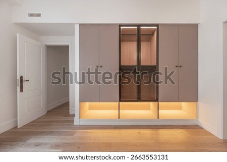 Vertical composition: tall white lacquered wood wardrobe with horizontal glass stripes and built-in chest of drawers
