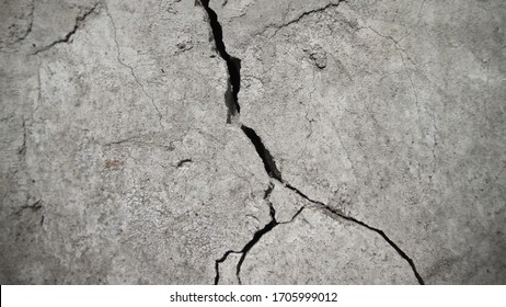 Vertical concrete crack on a rough texture. Retro effect of aging and destruction.