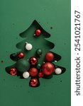 A vertical creative Christmas tree silhouette filled with colorful ornaments including red, green, and white balls, capturing the festive spirit and holiday joy