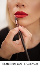 Vertical Cropped Shot Of A Makeup Artist Using Concealer Around The Lips Of A Woman With Red Lipstick