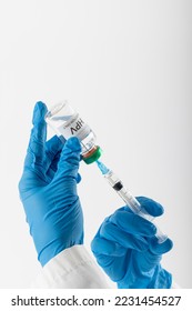 Vertical of doctor's gloved hands filling syringe from hpv vaccine vial, on white with copy space. Medicine, medical services, healthcare and health awareness concept. - Shutterstock ID 2231454527