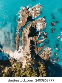 Vertical drone photo above ohope beach in New Zealand showing beaches, different rock formations, flora and fauna.