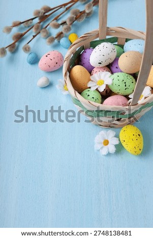 Vertical Easter greeting with painted egg in wicker basket and pussywillow branch arranged for elegant spring holiday celebration card design