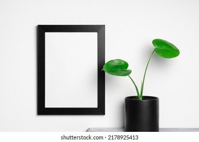 Vertical Empty Frame Mockup On White Wall With Flower Pot, Blank Mockup With Copy Space For Artwork