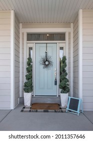 Vertical Entrance Of A House With Decorative Light Blue Front Door And Posts With Stone Bricks