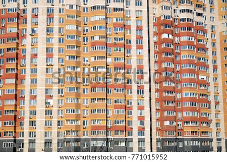 Vertical facade of a large multi-storey block of flats with many apartments front view closeup