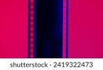 Vertical film strip on a red background, close up. 35mm film slide frame. Long, retro film strip frame. Copy space.