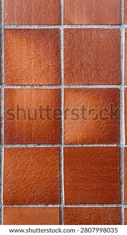 Vertical floor texture background of square rustic terracotta ceramic tiles with gray grout. Symmetrical top-down framing, full frame composition, and critical sharpness.