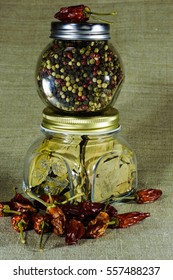 Vertical frame with jars of whole pepper, bay leaf and chili.