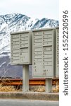 Vertical frame Mailboxes with compartments and numbers against snowy mountain and cloudy sky
