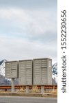 Vertical frame Selective focus mailboxes beside a road against snowy mountain and cloudy sky