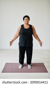 Vertical Full Length Portrait Of Black Senior Woman Enjoying Yoga Indoors