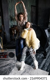 Vertical Full Length Portrait Of Two Female Vogue Dancers Posing In Dark Grunge Studio