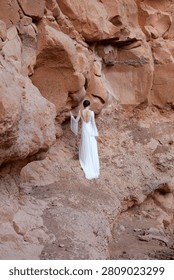 Vertical Full Length View of Bride in Backless Boho Wedding Dress Against Red Canyon Wall
